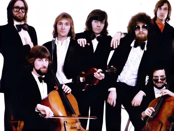 Past daily archive of classic 1960s rock band with instruments, musicians in tuxedos with violins and ukulele, music history and news recordings, vintage music photos.