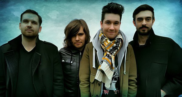 Youthful band members posing outdoors with a dynamic sky background, showcasing musical group promotion and concert imagery.