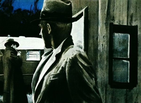 A vintage man in a hat standing near a wooden building, capturing a nostalgic scene related to historical news and music archives.