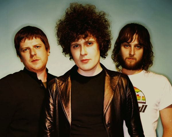 Retro music band photo with three indie rock musicians, historical music archive, and cultural artists representing past daily news and music history.