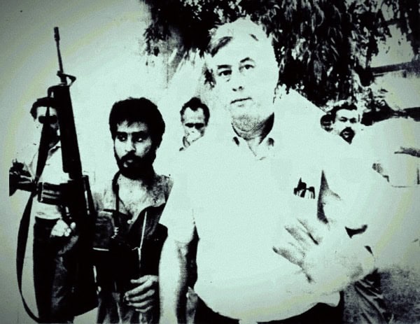 Gun-wielding man with group of protesters in a black-and-white historic photo.