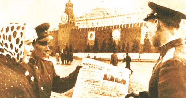 Vintage Soviet soldiers reading a newspaper near the Kremlin, capturing historical news and wartime imagery.