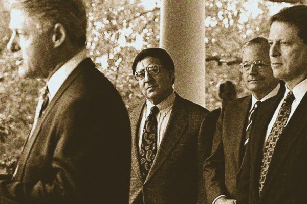 Men in suits attending a formal event outside in a park setting, retro black and white photograph capturing classic 1960s style and fashion, emphasizing news, history, and music archives.