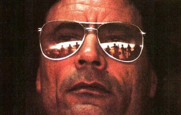 Close-up of a man wearing reflective sunglasses, highlighting themes of news, history, and music in a sound archive context.