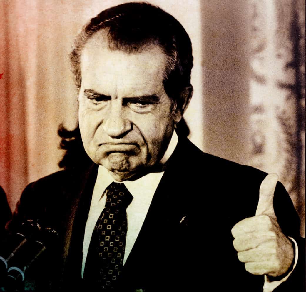 Image of Richard Nixon with a stern expression, giving a thumbs-up gesture, captured during a historic moment in American political history, relevant to news, history, and iconic American figures.