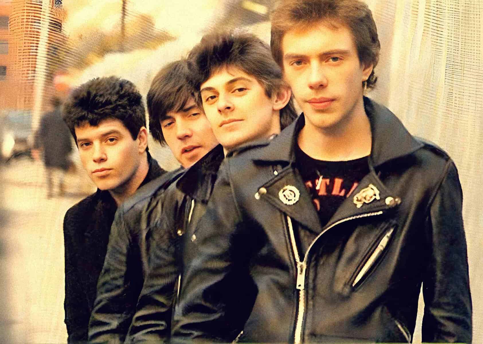 A sound archive featuring classic music news and history, showcasing a vintage photo of a 1980s band in leather jackets, emphasizing music history and archival audio recordings.