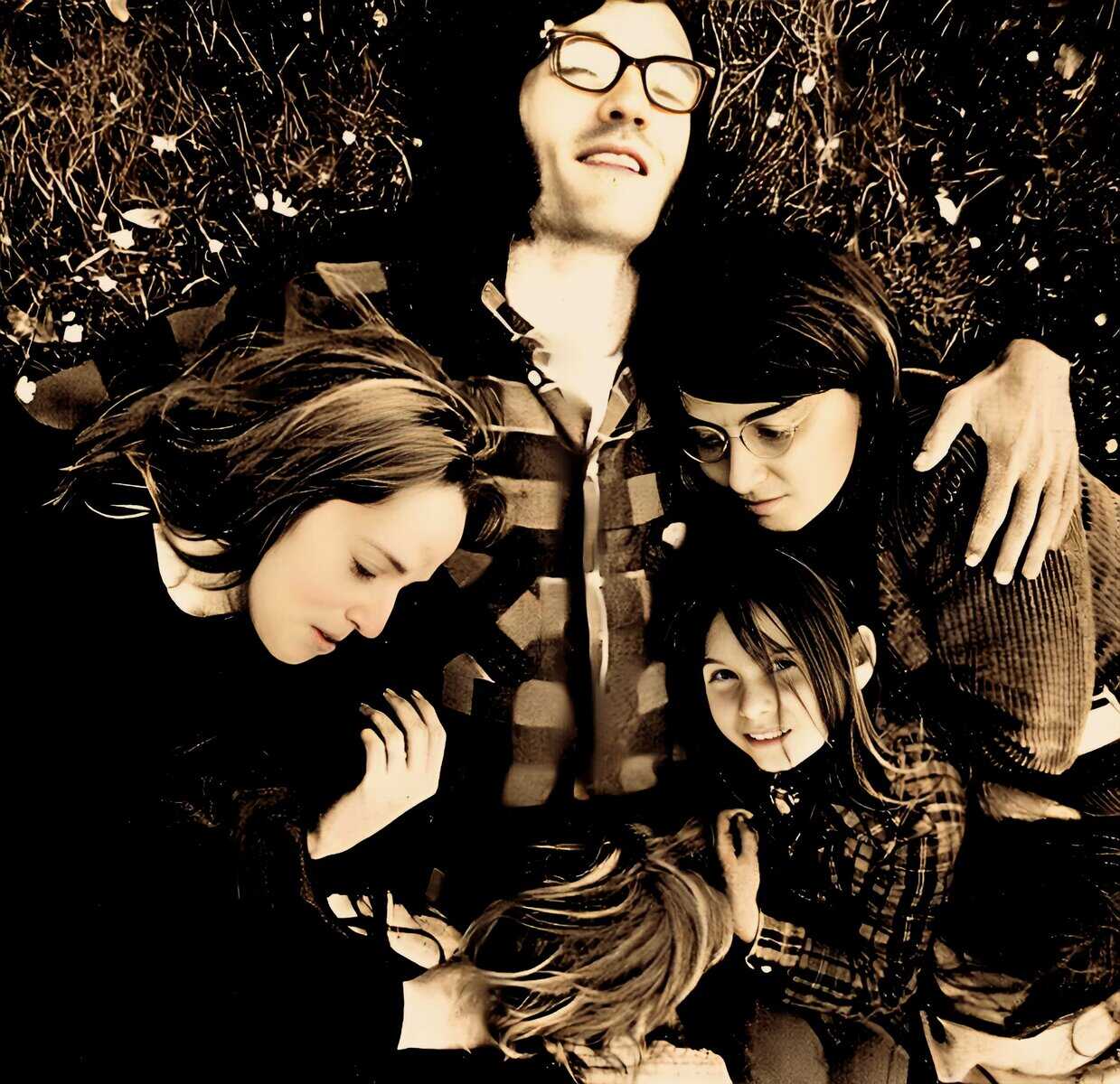 A group of five young people lying on the grass, enjoying music and history from past daily archive, capturing sound recordings of news and cultural moments, nostalgic and vintage vibe.