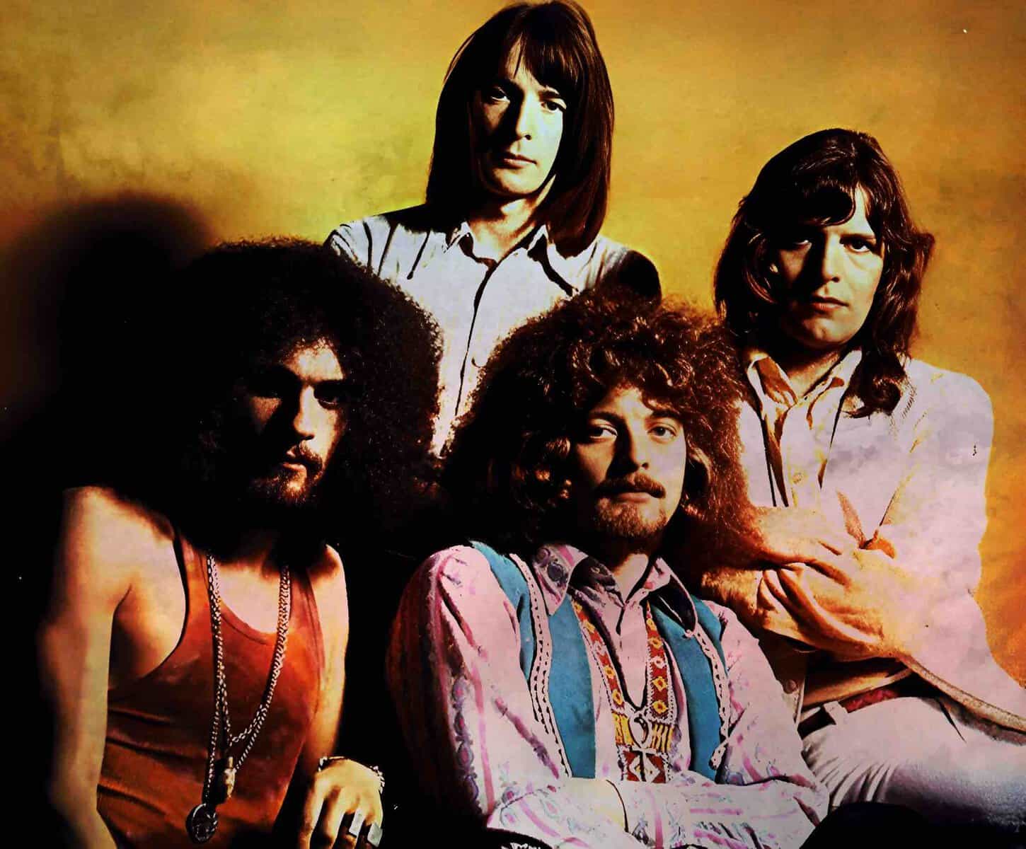 Vintage rock band photo featuring members with distinctive hairstyles and 1970s fashion, highlighting music history and classic rock culture.