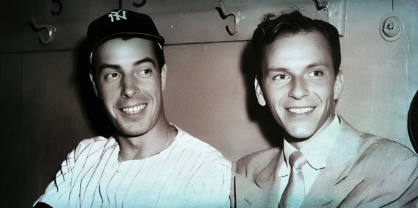 Vintage black and white photo of two smiling men, one wearing a baseball cap, in a radio broadcast setting, representing historical news and music archives for Past Daily.