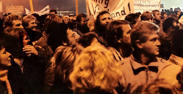 People gathered at a protest or rally during the night, holding signs and demonstrating support for social or political causes, capturing a moment of activism and community engagement.