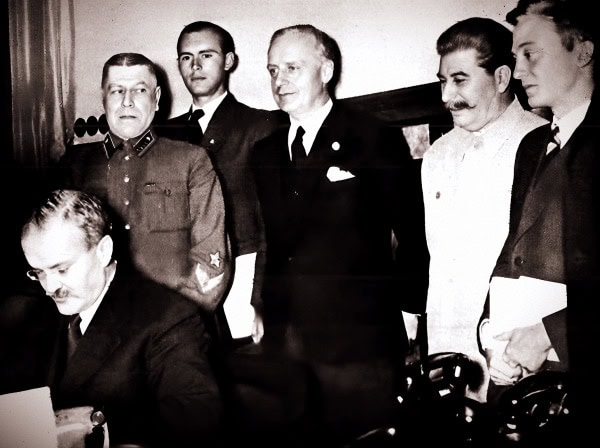 Historical black and white photo of world leaders during a 20th-century meeting, showcasing diplomatic discussions and historic political figures in formal attire.