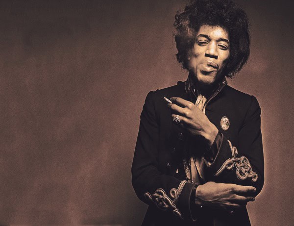 A vintage-style photograph of Jimi Hendrix in a black jacket, holding a cigarette, with a neutral background, emphasizing music history and legendary rock icons for SEO.