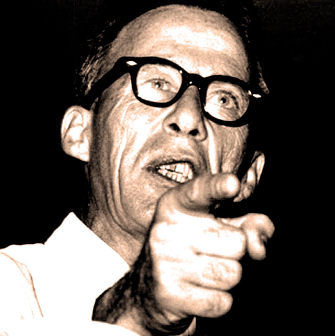 Pointed elderly man with glasses speaking, vintage black and white photo, iconic speech and political history, archival news image for sound archive of news, history, and music.