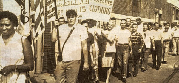 Protesters marching in a historic civil rights demonstration, holding signs advocating for fair clothing labor standards.