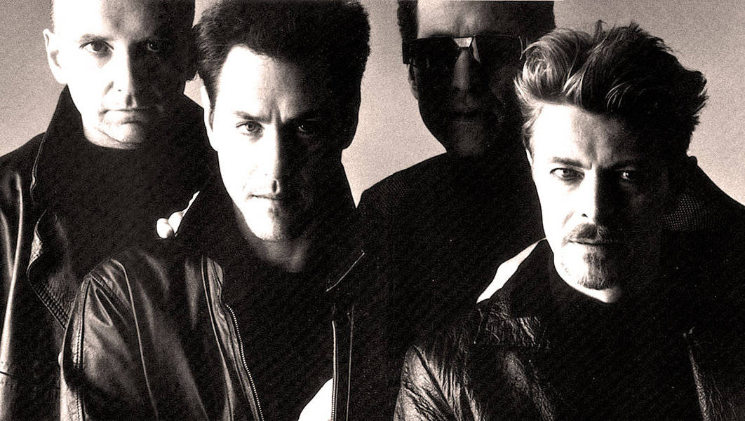 Black and white photo of U2 band members, showcasing their intense expressions, leather jackets, and rock star style, reflecting iconic music history.