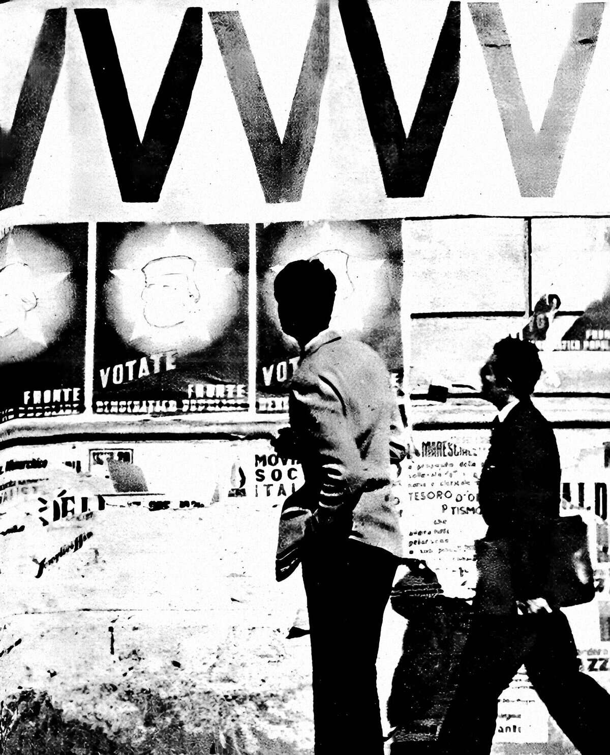 Vintage black and white photo of two people walking past political campaign posters and a large "WWW" sign, capturing urban nightlife and historical street scene.