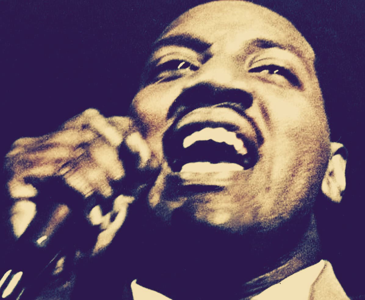 Black male singer passionately performing, capturing the essence of music history and jazz culture, with an energetic expression ideal for an archive of news, music, and historical sound recordings.