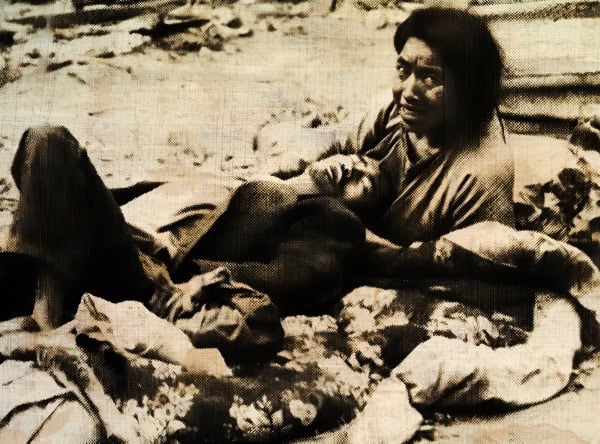 A woman and child resting outdoors on rocky terrain, illustrating resilience and survival in a historical or wartime context.