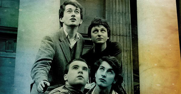 Vintage black and white photo of four young adults standing outdoors, representing nostalgic news, history, and music archives from Past Daily.