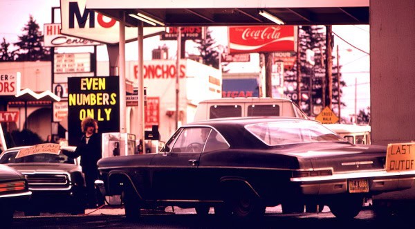 A vintage 1960s gas station scene with classic cars, neon signs, and nostalgic Americana ambiance.