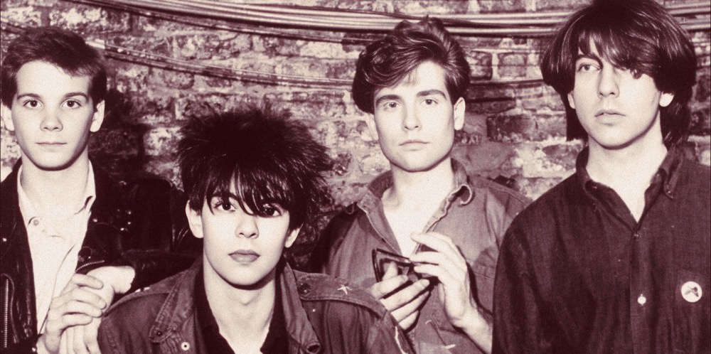 Photo of The Smiths band members in black and white, showcasing their iconic 80s punk rock style, with a brick wall background, capturing the essence of alternative music history.