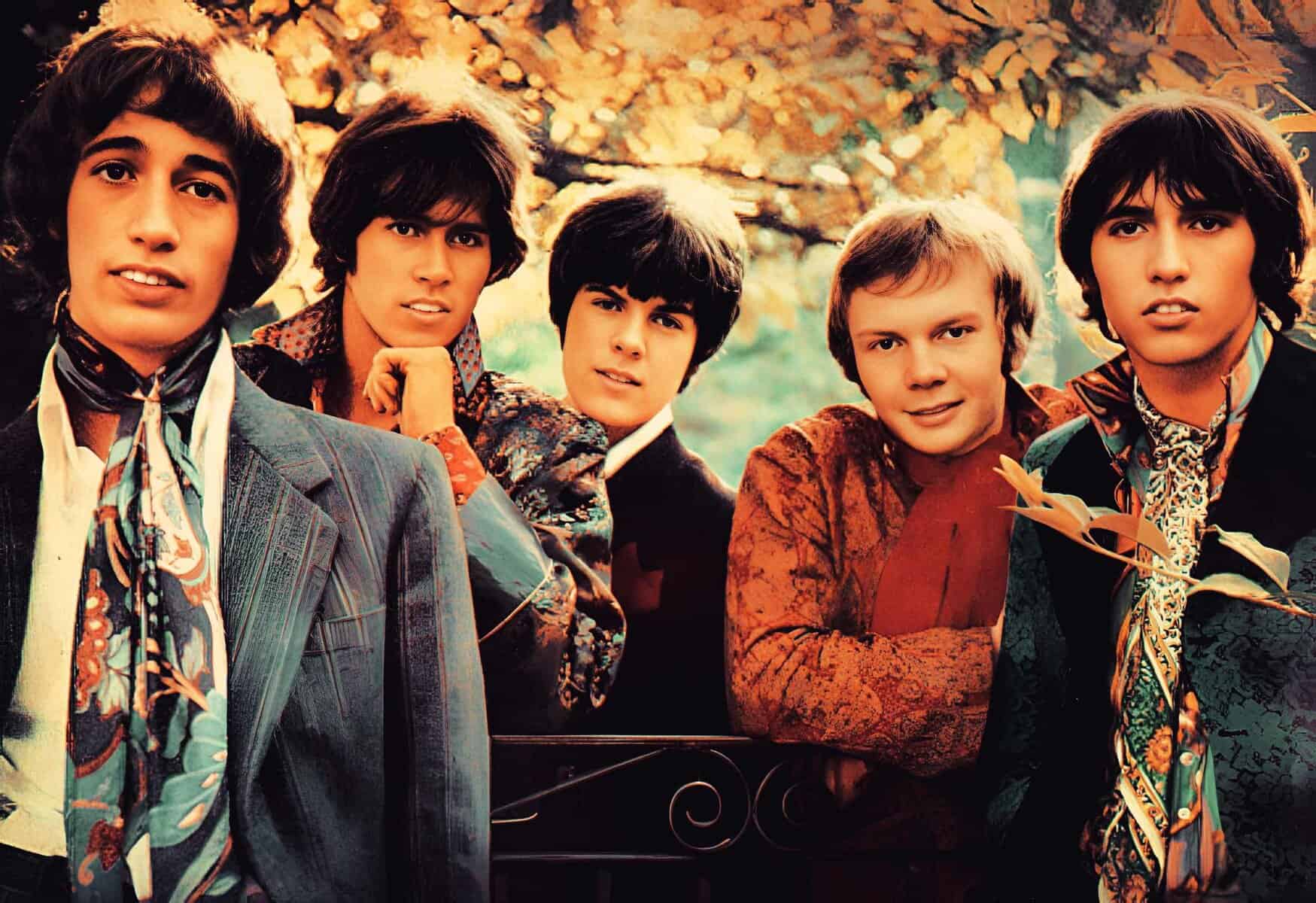 A vintage photo of The Monkees, a popular band from the 1960s, dressed in colorful, psychedelic clothing outdoors showcasing iconic music history and pop culture of that era.
