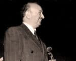 Elegant vintage photograph of a smiling man in a suit holding a conductor's baton, symbolizing classic music performances and historical sound archives.