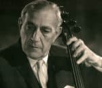 Veteran male jazz musician playing the double bass in a black and white photograph, showcasing a classic musical performance.