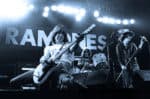 Guitarist and drummer performing on stage at a Ramones concert, showcasing classic punk rock music and energetic live performance.