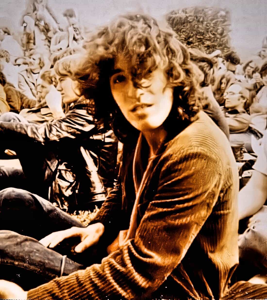 Girl with curly hair at concert or music event, vibrant atmosphere, lively crowd background, vintage style, social gathering, entertainment, live music experience, music festival, artistic performance, nostalgic vibe, black and white photo, expressive face, dynamic scene, music lovers, cultural event, popular music, crowd participation, energetic environment, event photography, audience engagement, stage presence, iconic music moment, entertainment photography, concert crowd, music appreciation, lively social scene, music history, past daily archive, historical music event, classic concert scene.