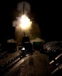 Explosive naval artillery firing at night during a military operation, military weapons, night combat scene, navy vessel, military technology and warfare, past daily historical archive.