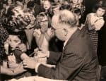 Child receiving a vaccination in a school setting, with children in the background showing concern and curiosity, capturing a historic moment in children's health and childhood immunization records.