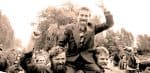 Historic protest rally with a man raising fist, crowd of supporters, outdoor setting, activism, social movement, vintage black-and-white photo, capturing news, history, and political advocacy.