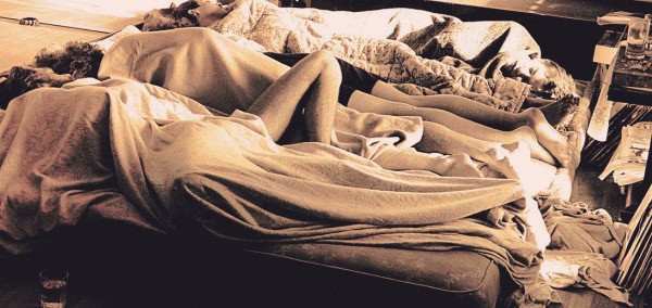 Disorganized bedroom with rumpled sheets and unmade bed, cluttered space, vintage style, cozy home environment, showing a messy but lived-in space.