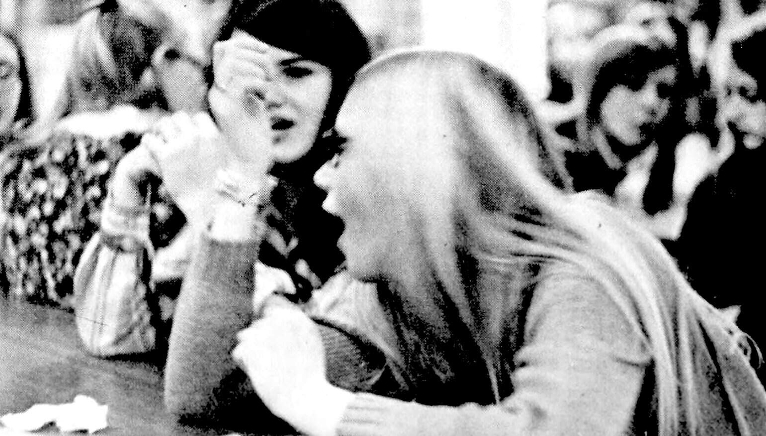 Young woman and elderly woman engaged in conversation at a news and history archive.