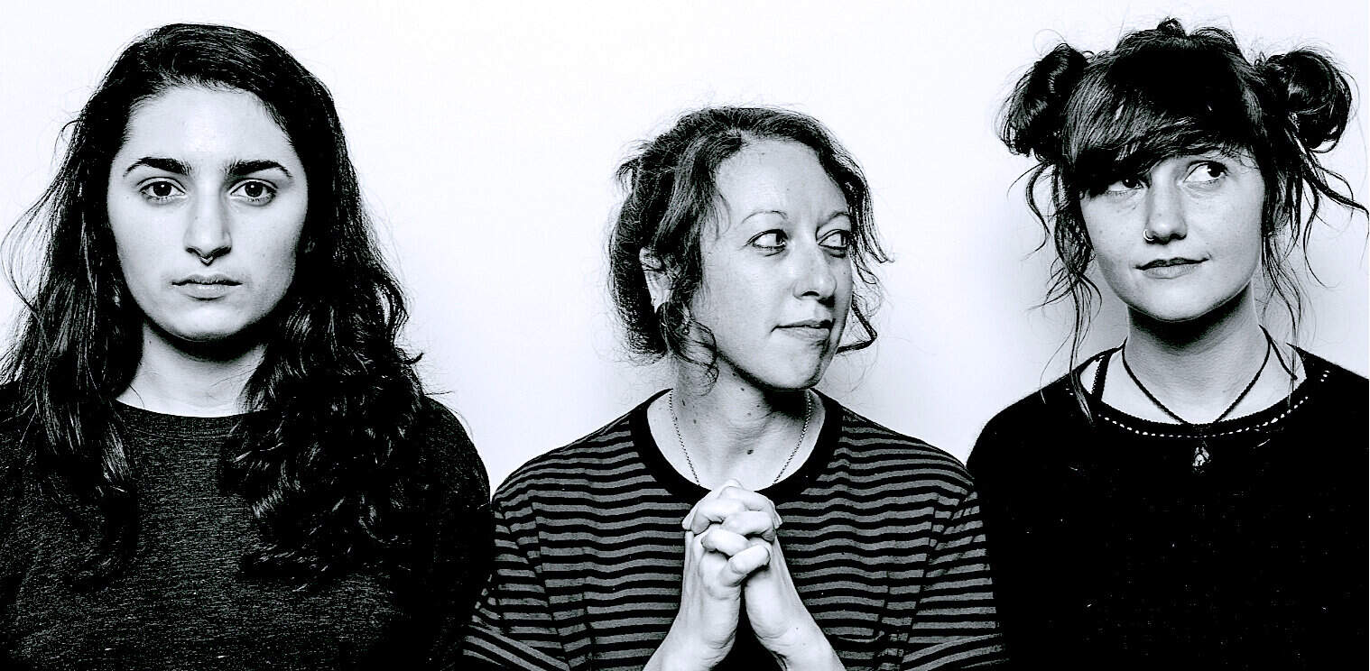 Women musicians with vibrant expressions, black and white portrait, alternative music scene, artistic photo, indie band members.