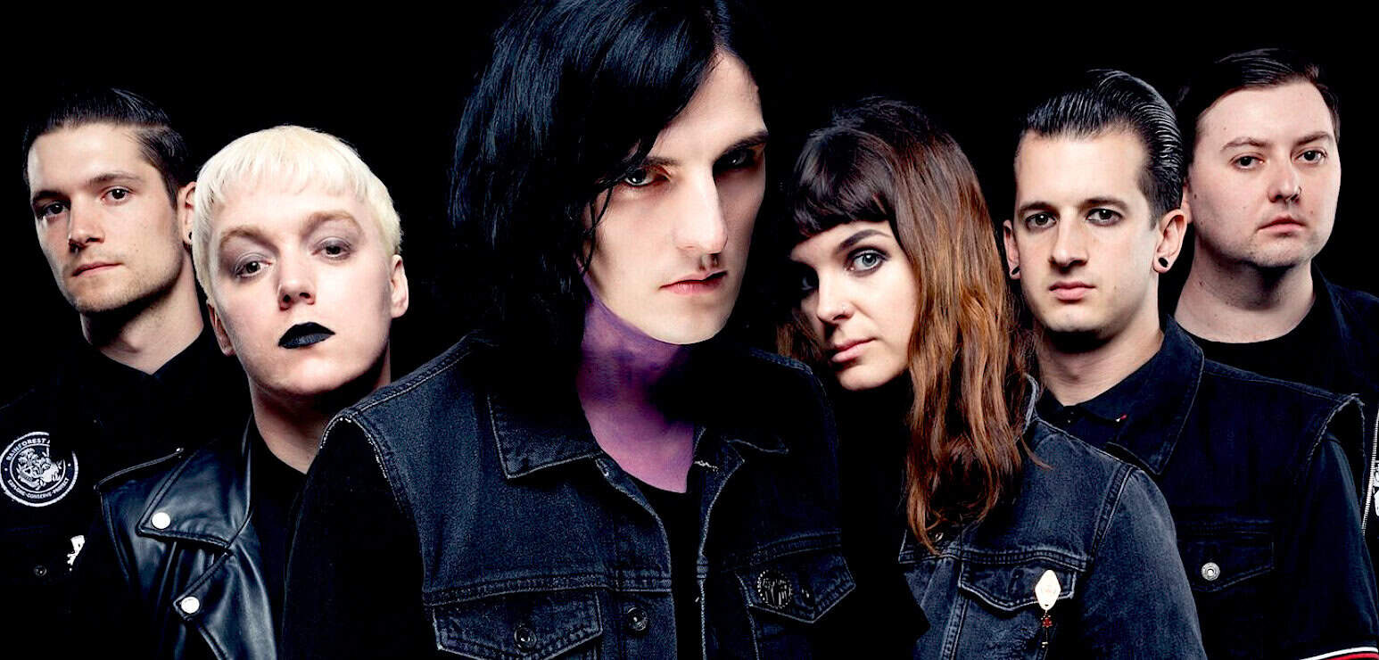 Band members of punk rock music group with dark hair and edgy style for music history and news archive on Past Daily.