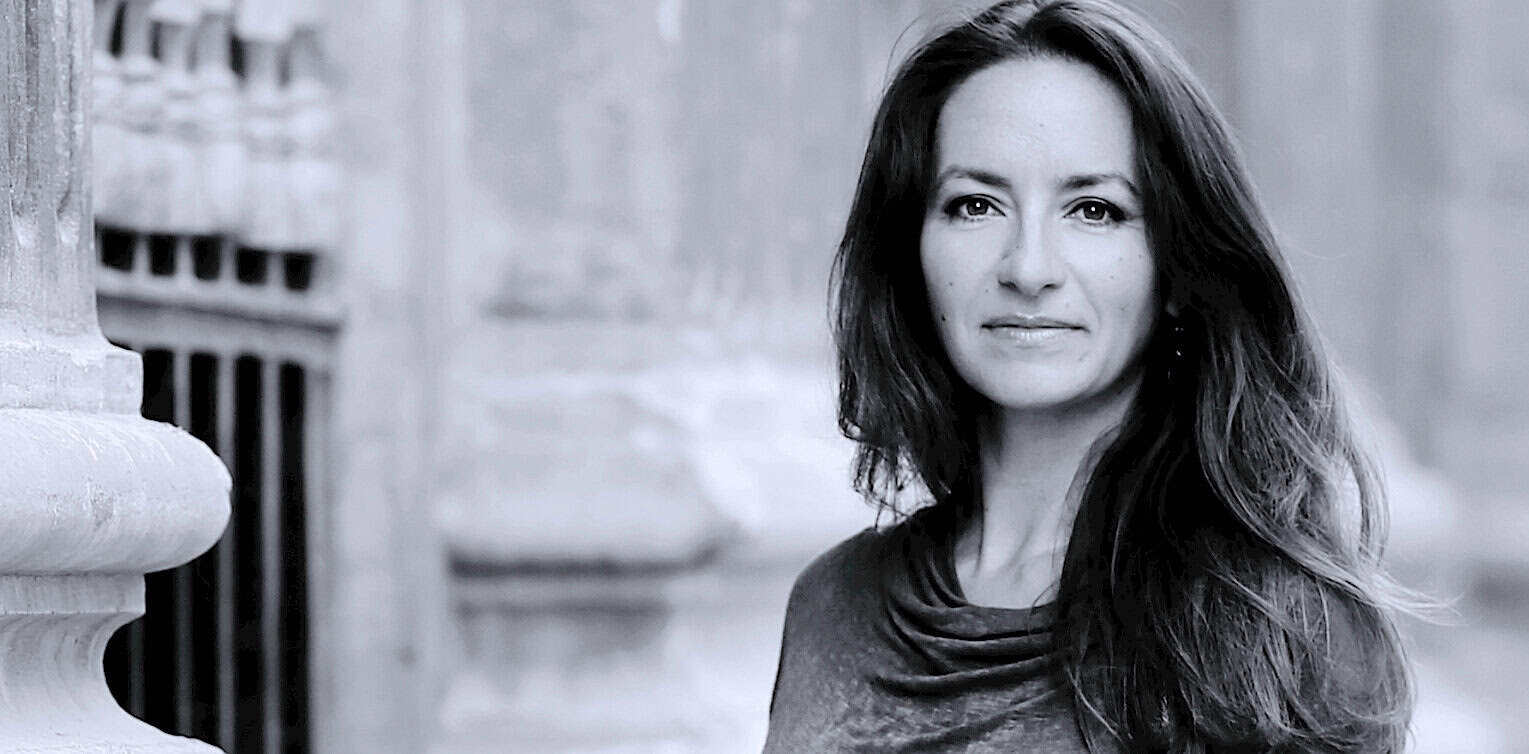 Portrait of a woman with long dark hair outdoors, black and white photo, evocative of history and music archives, capturing the essence of Past Daily's sound archive collection.