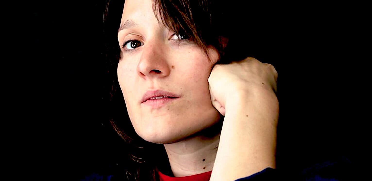 Past daily news archive woman with short dark hair and fair skin posing with hand near face.