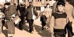 Old black and white photo of people walking on a busy street, illustrating historical life, daily life during wartime, and urban culture.
