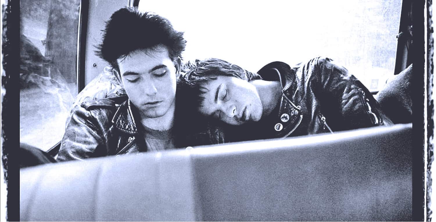 Young men resting on a bus, listening to music and relaxing, capturing the essence of youth, friendship, and music culture for nostalgic sound archive and music history enthusiasts.