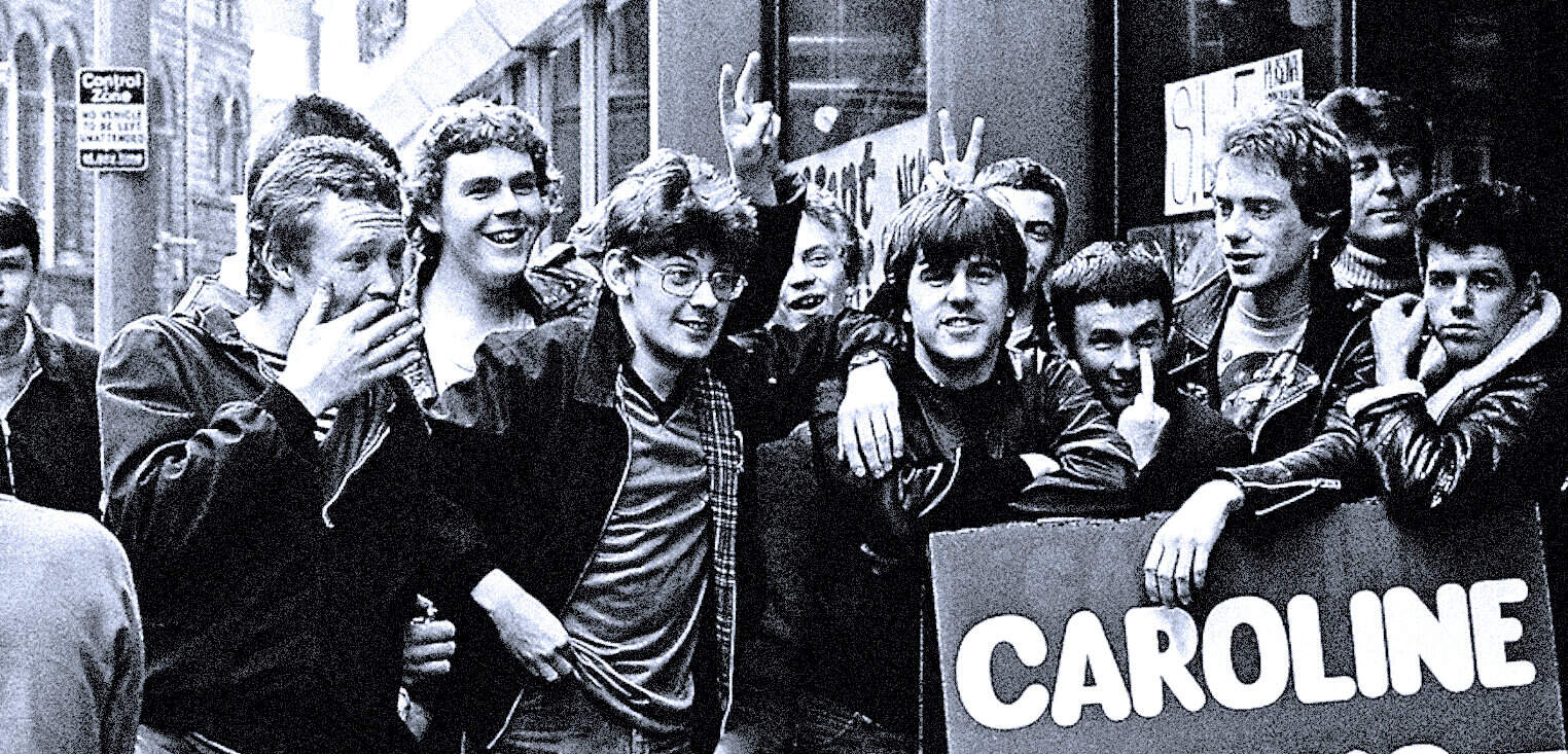 People protesting for social change on a city street in support of Caroline, holding a sign, with diverse youth embracing activism, vital part of historical news and music archives.