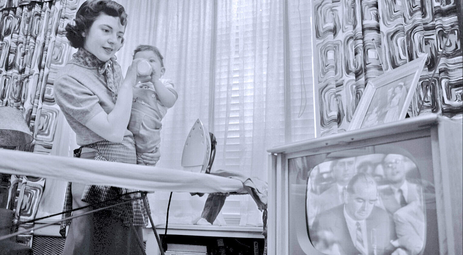 Vintage family watching television with black-and-white news broadcast, mid-20th century media scene, nostalgic TV era, historical news archive, early television technology, past daily news, vintage TV set, mid-century domestic life.