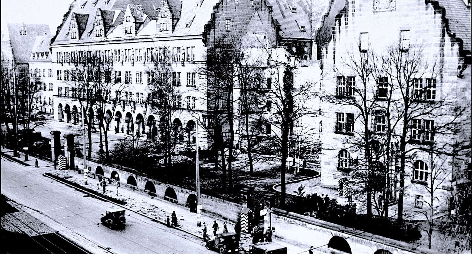 Ancient European building with Gothic architecture in a city street during winter, black and white photo showcasing historical architecture and urban life.