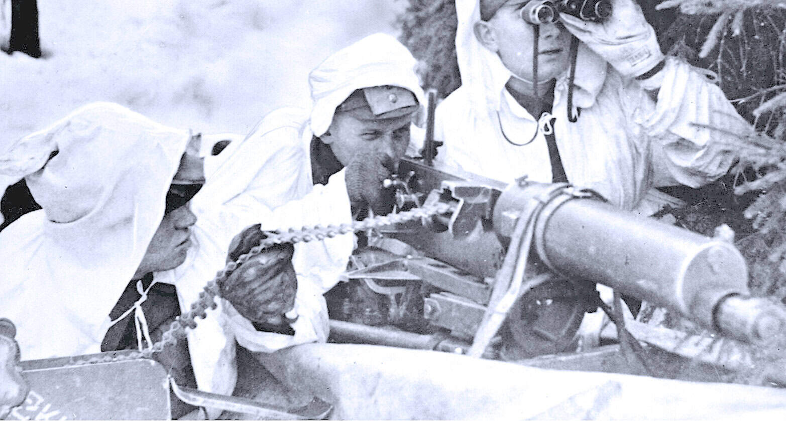 Soldiers operating a military weapon in a jungle setting, historical black and white photo.