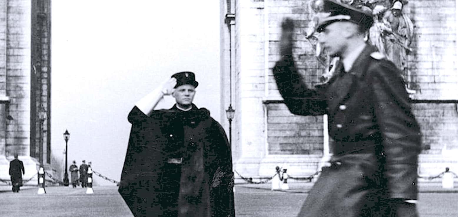 Saluting police officer in uniform during a historical event, black and white photo, vintage law enforcement scene, early 20th-century police attire, police salutation ceremony, historical police force imagery, nostalgia for law enforcement history.
