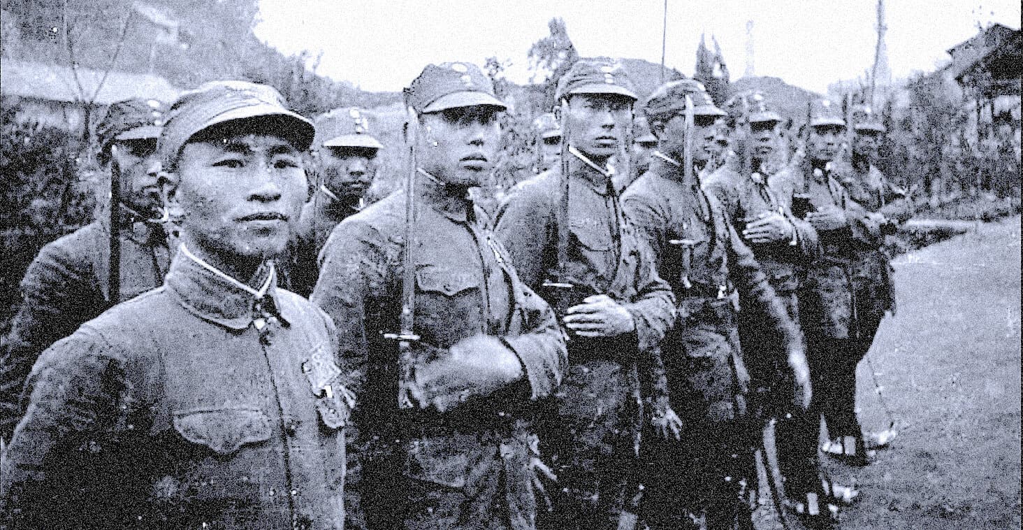 Japanese soldiers standing in formation during wartime, holding rifles, wearing military uniforms, historical black-and-white photograph, World War II era, related to news, history, and military archives.