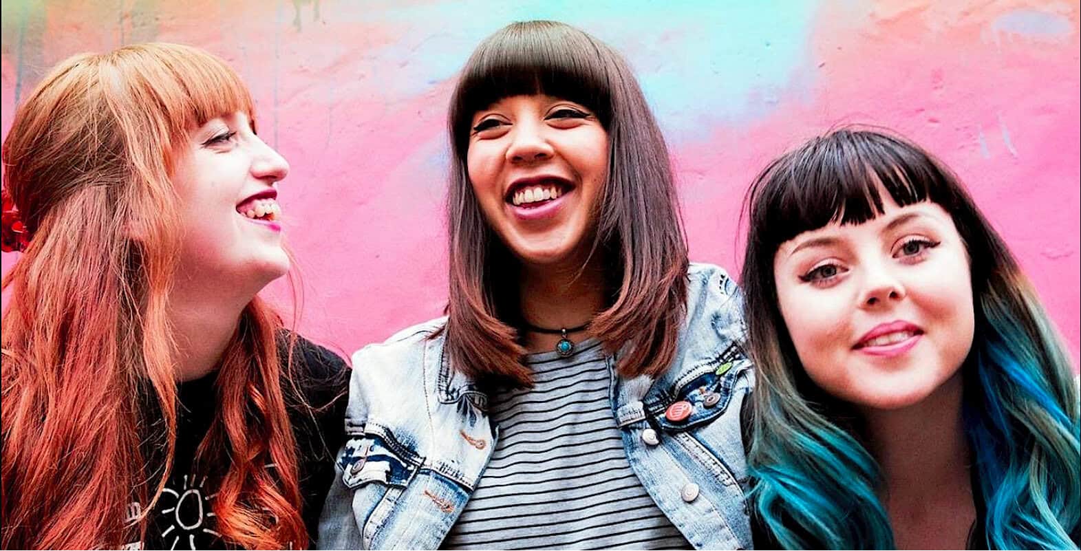 Red-haired woman smiling at friend, young people enjoying music and news archive, colorful background, vibrant atmosphere, social connection, past daily history, and pop culture.