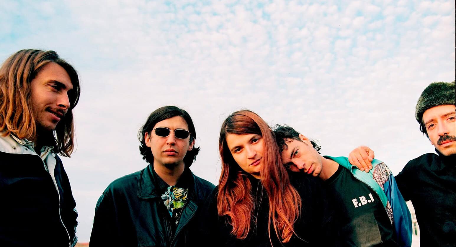 Past Daily music archive featuring a band with young adults, 90s alternative rock style, outdoor sky background. Perfect for news, history, and music history archives.