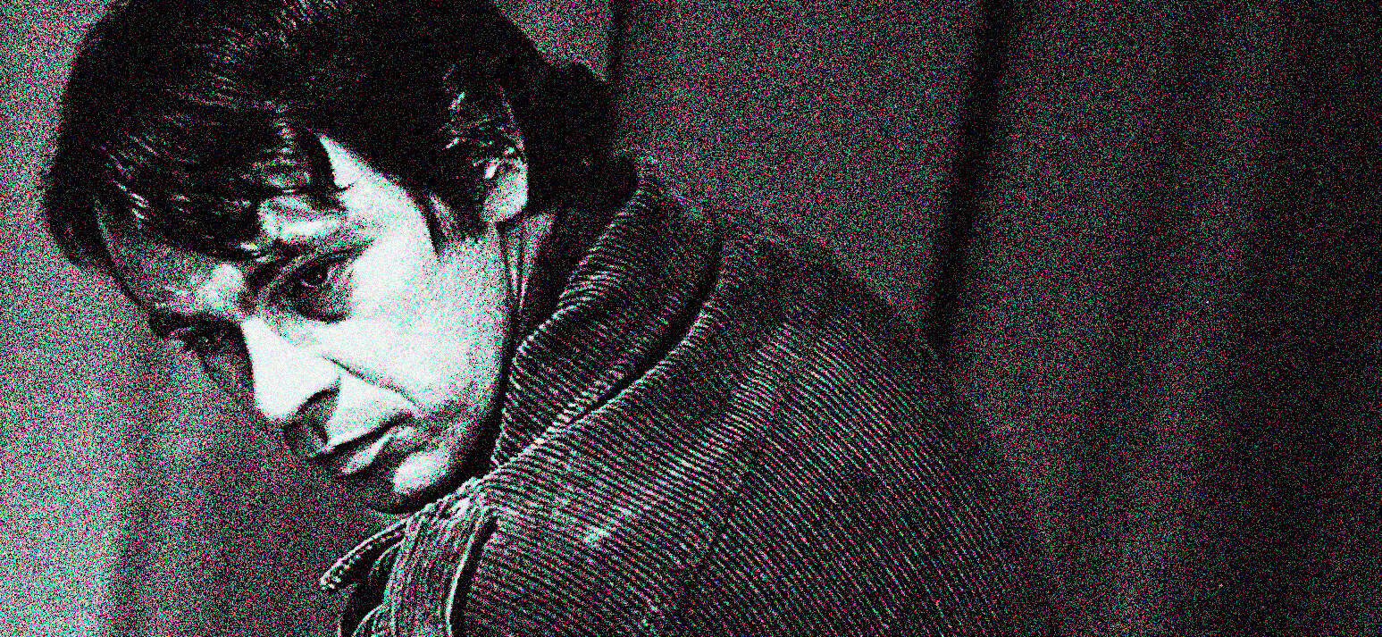 Black and white photo of a young man with dark hair, wearing a striped jacket, representing vintage news, history, and music archival content from Past Daily.